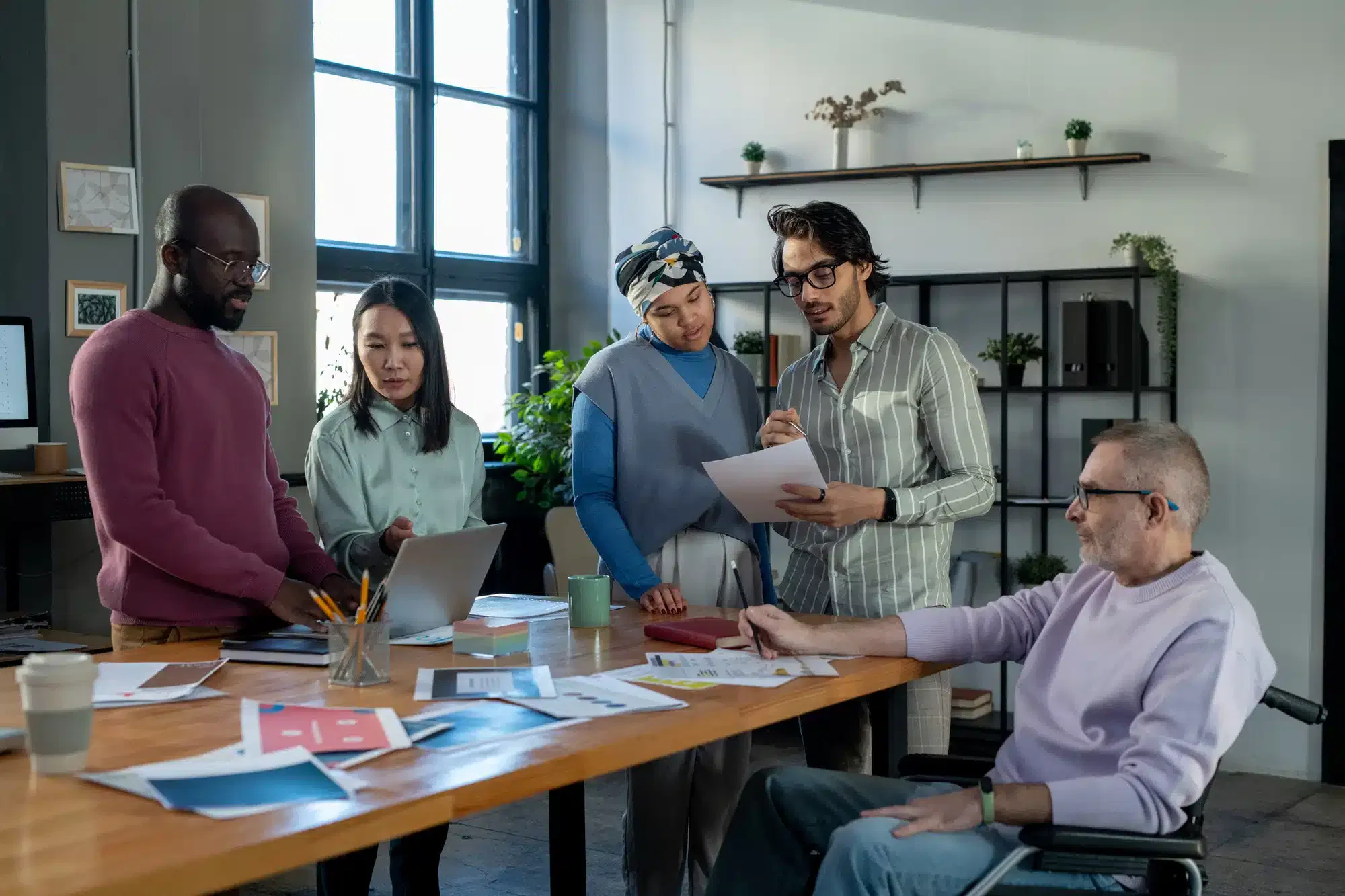 Mitarbeiter im Unternehmen stehen am Tisch.Datenschutz im Unternehmen Sichern Sie Ihr Unternehmen mit Expertise – Zertifizierte Datenschützer stehen Ihnen zur Seite!